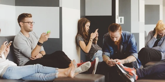  Junge Menschen in einem Raum mit Smartphones
